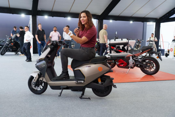 Visitor trying a silver YADEA electric scooter inside the Festival Interlagos 2026 booth