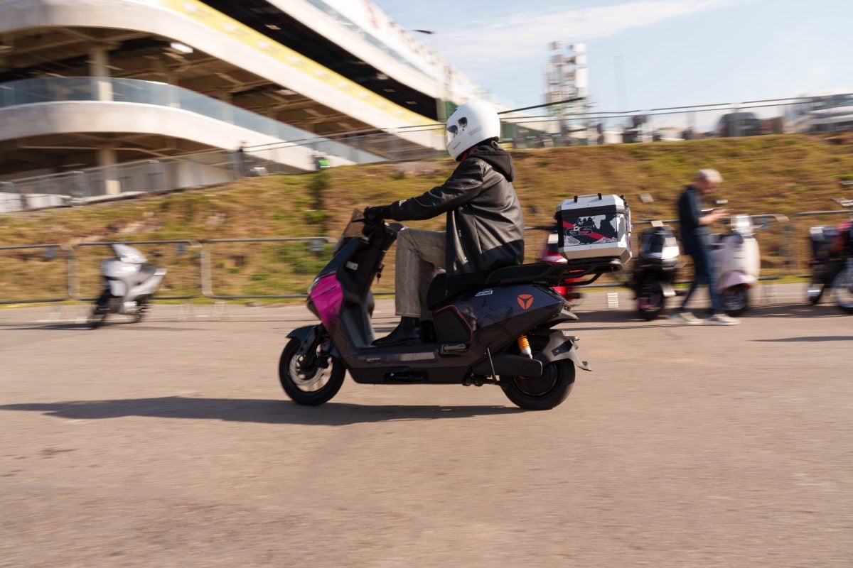 Helmeted rider testing a pink and black YADEA GS70 PRO on an outdoor course at Festival Interlagos 2026