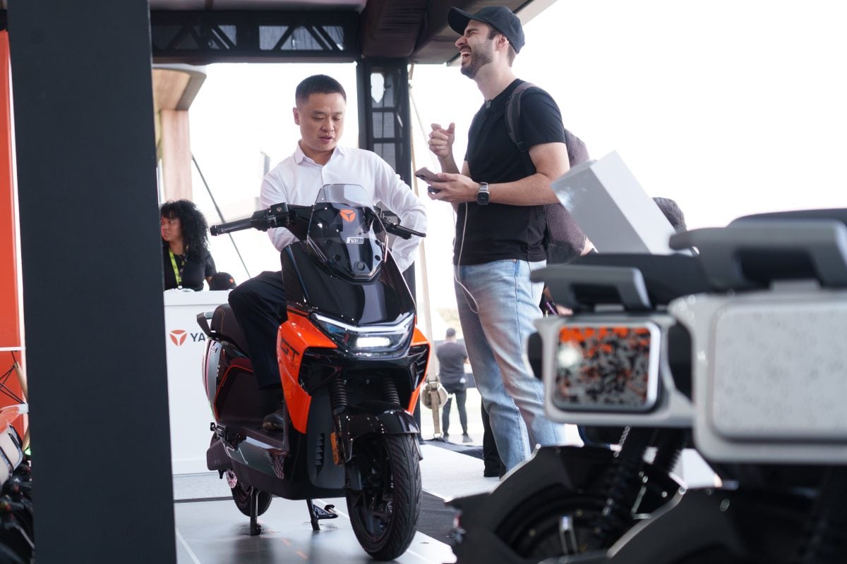 Festival visitors examining the orange and black YADEA GS70 PRO at the brand’s display