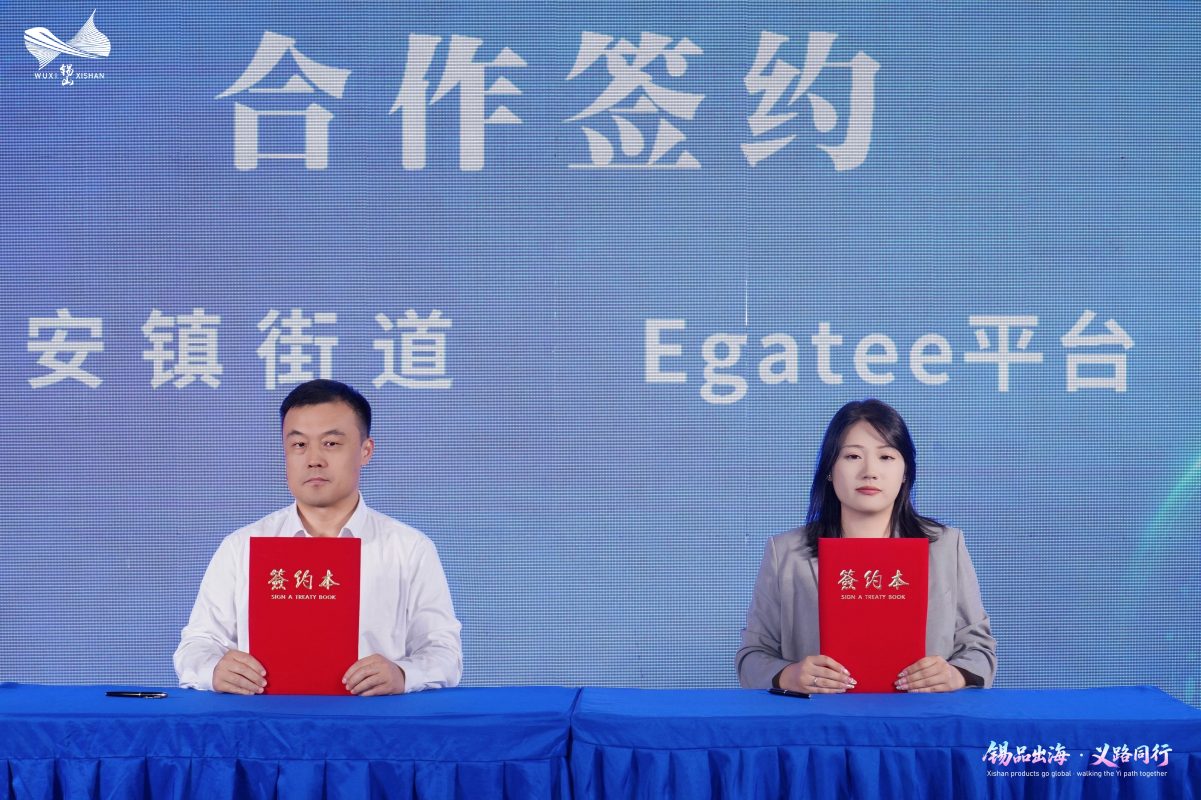 Anzhen Subdistrict and Egatee representatives hold signed cooperation agreements on stage.