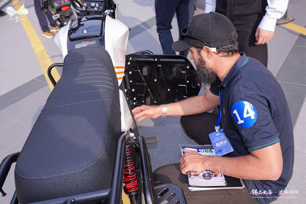 Overseas buyer inspects an electric scooter rear compartment and suspension
