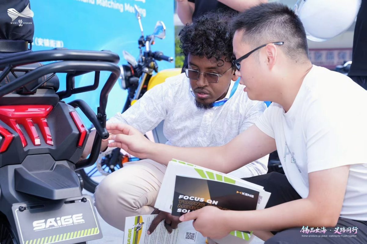 Buyer and Xishan supplier examine the rear section of an electric scooter
