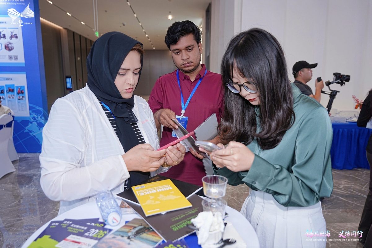 Buyer and supplier representatives review catalogs and contact details during matchmaking